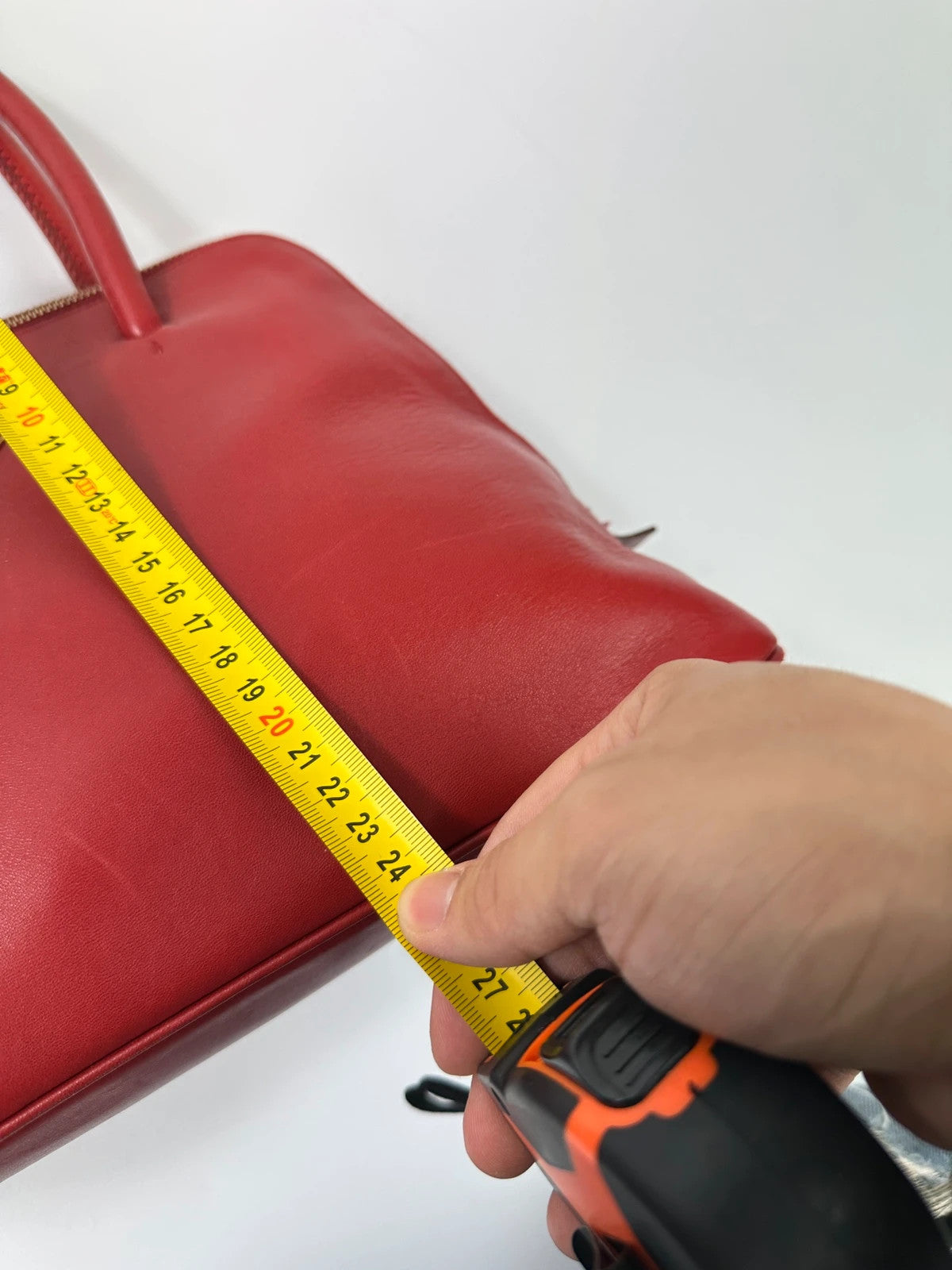 Prada red leather handbag with gold hardware and vintage logo detail.