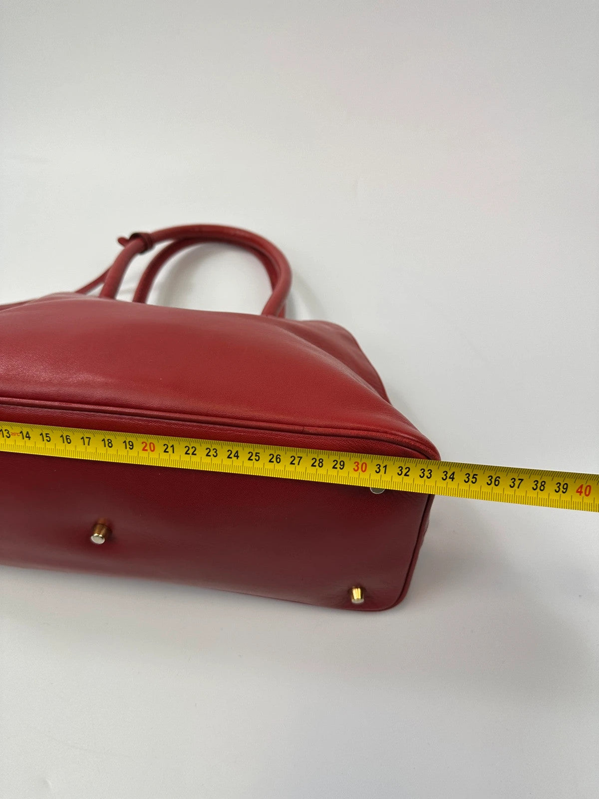 Prada red leather handbag with gold hardware and vintage logo detail.