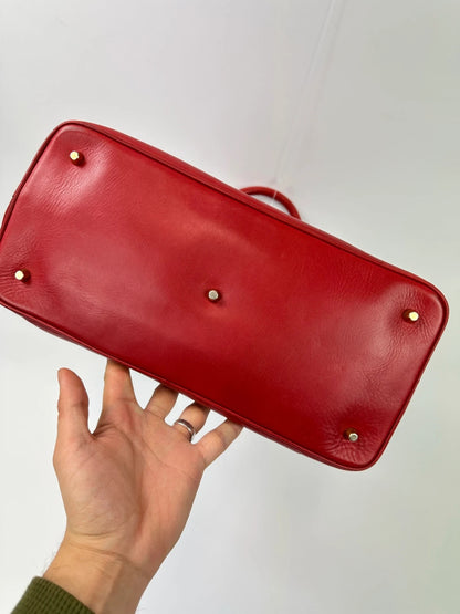 Prada red leather handbag with gold hardware and vintage logo detail.