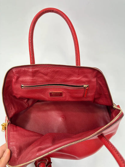 Prada red leather handbag with gold hardware and vintage logo detail.