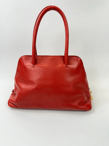 Prada red leather handbag with gold hardware and vintage logo detail.