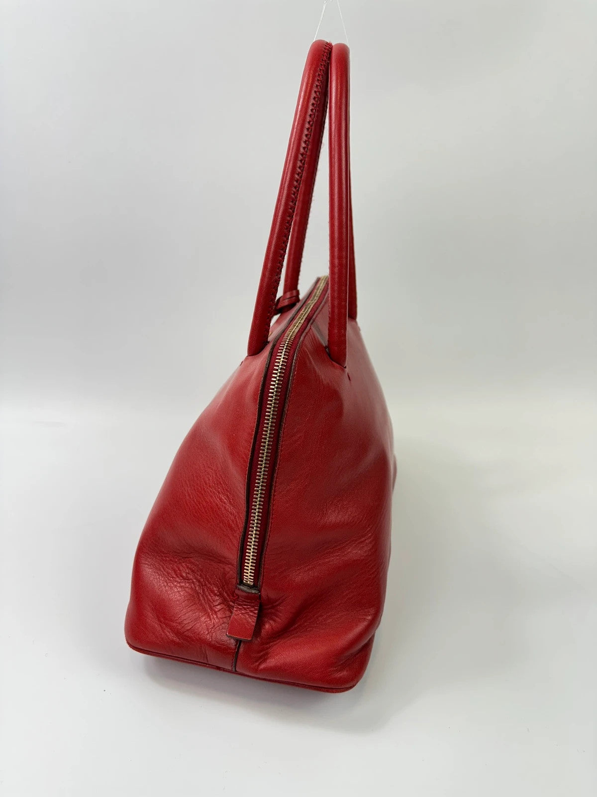 Prada red leather handbag with gold hardware and vintage logo detail.