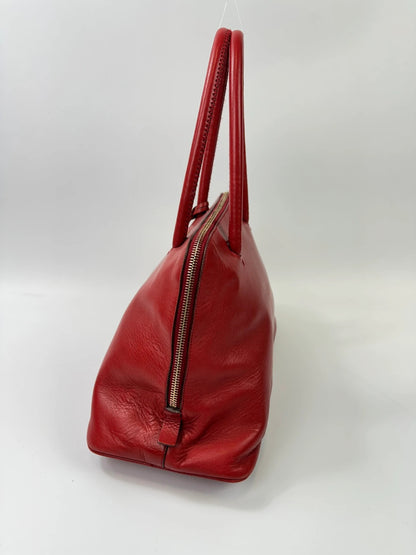 Prada red leather handbag with gold hardware and vintage logo detail.