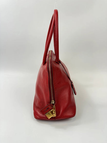 Prada red leather handbag with gold hardware and vintage logo detail.