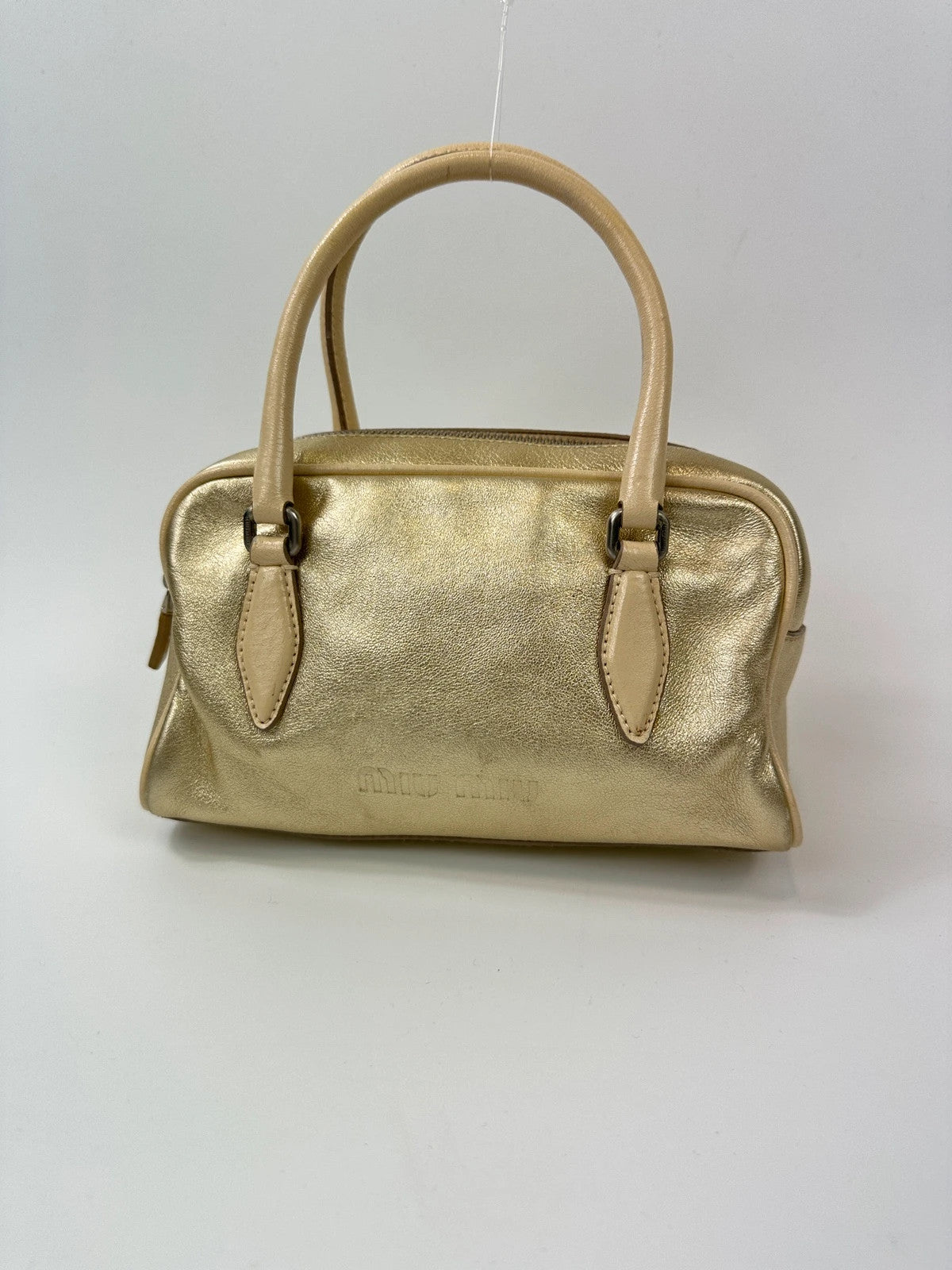 Miu Miu gold leather mini handbag with shiny glitter finish and logo detail.