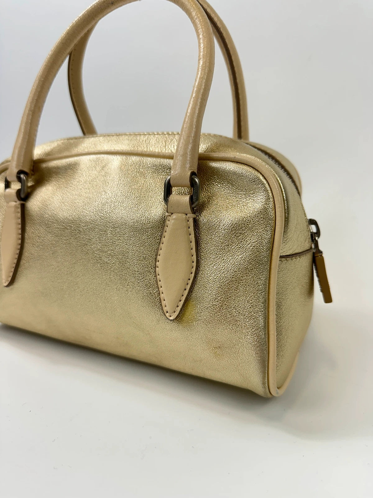 Miu Miu gold leather mini handbag with shiny glitter finish and logo detail.