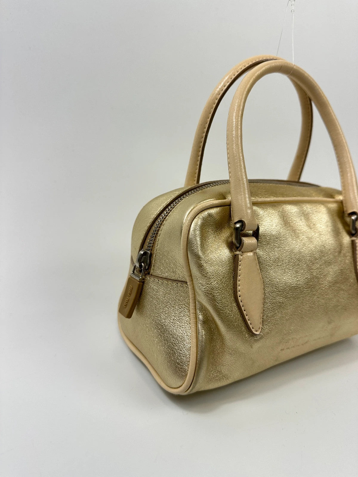 Miu Miu gold leather mini handbag with shiny glitter finish and logo detail.