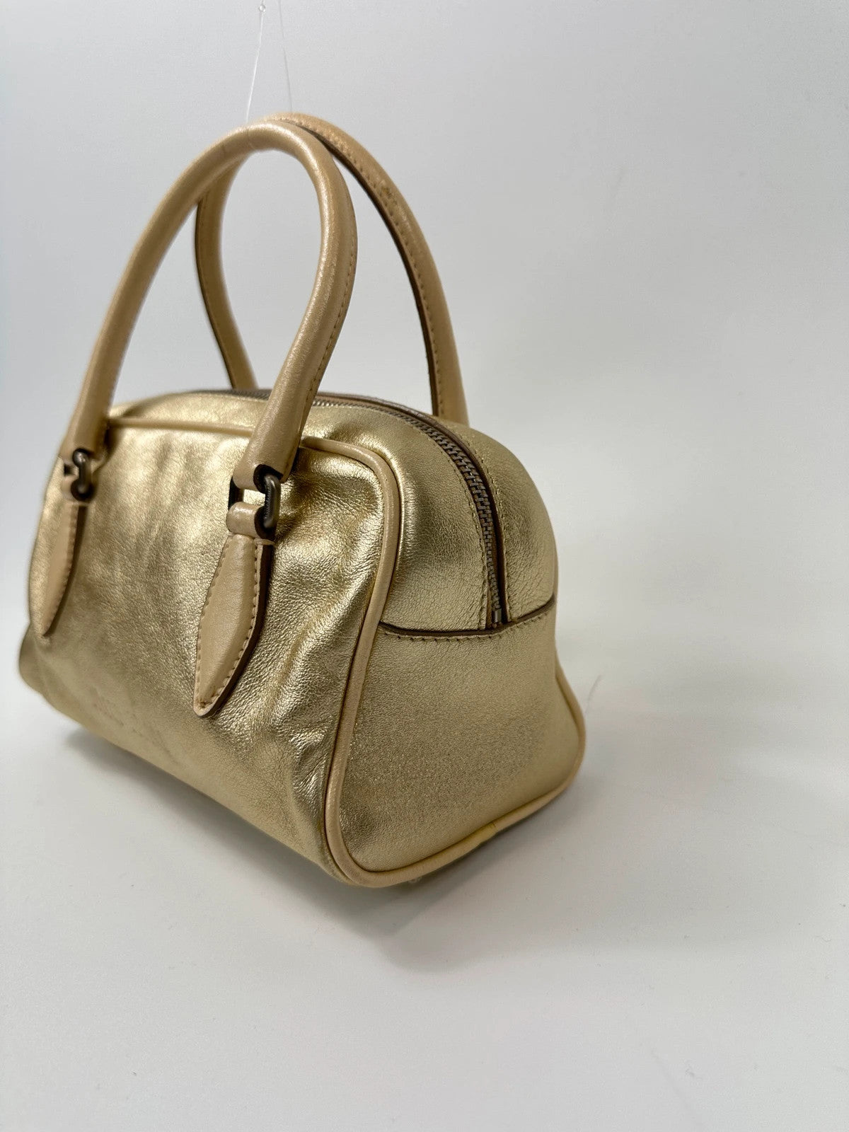Miu Miu gold leather mini handbag with shiny glitter finish and logo detail.