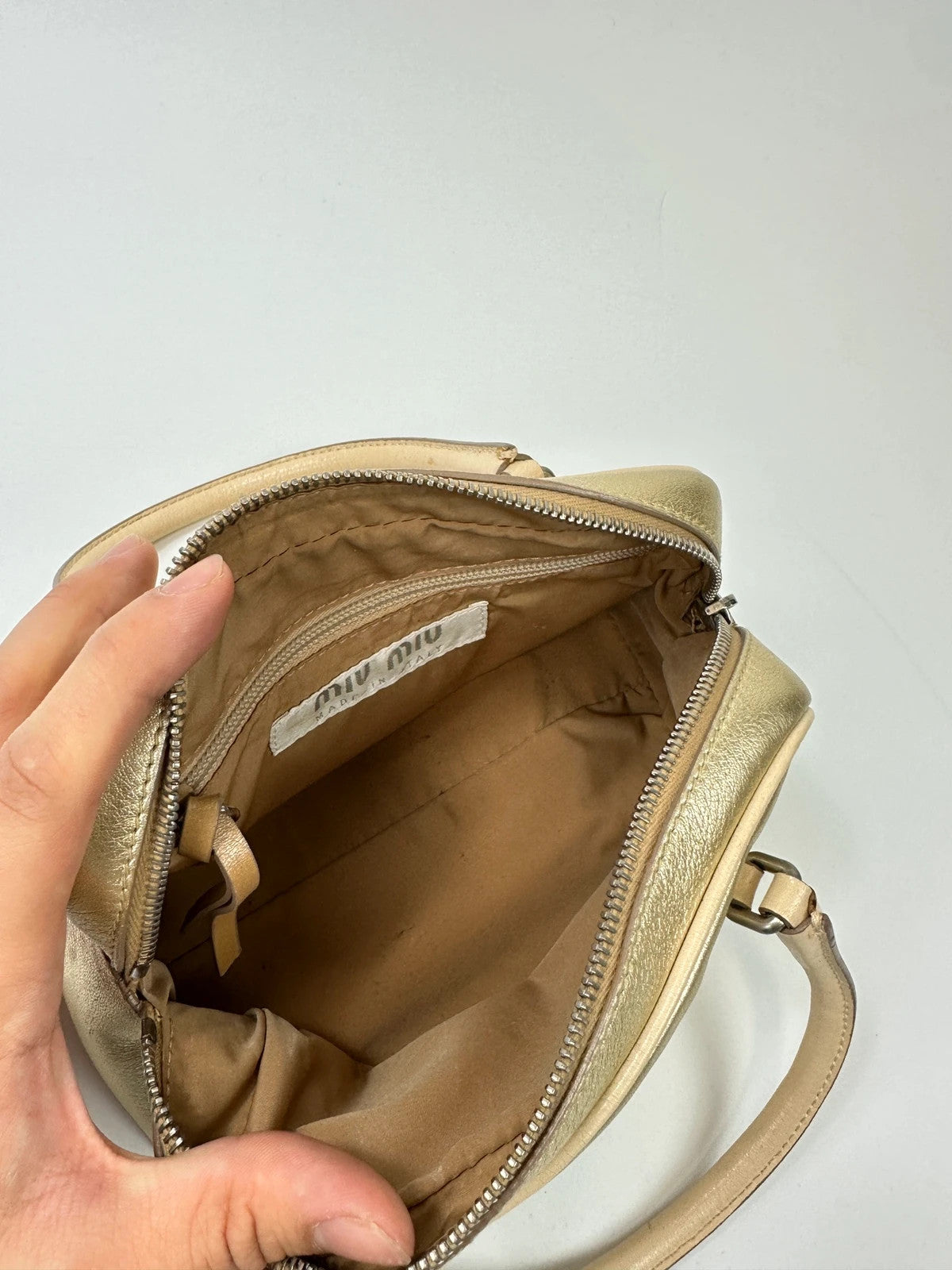 Miu Miu gold leather mini handbag with shiny glitter finish and logo detail.