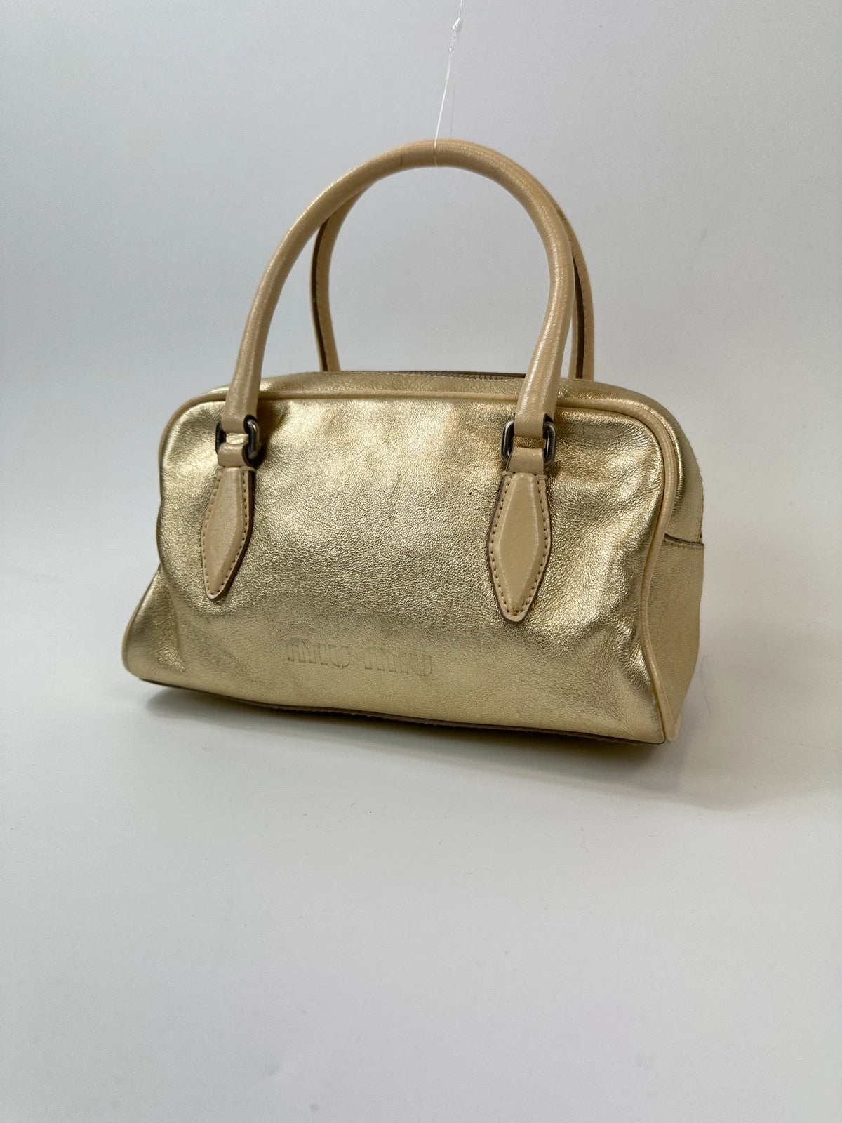 Miu Miu gold leather mini handbag with shiny glitter finish and logo detail.