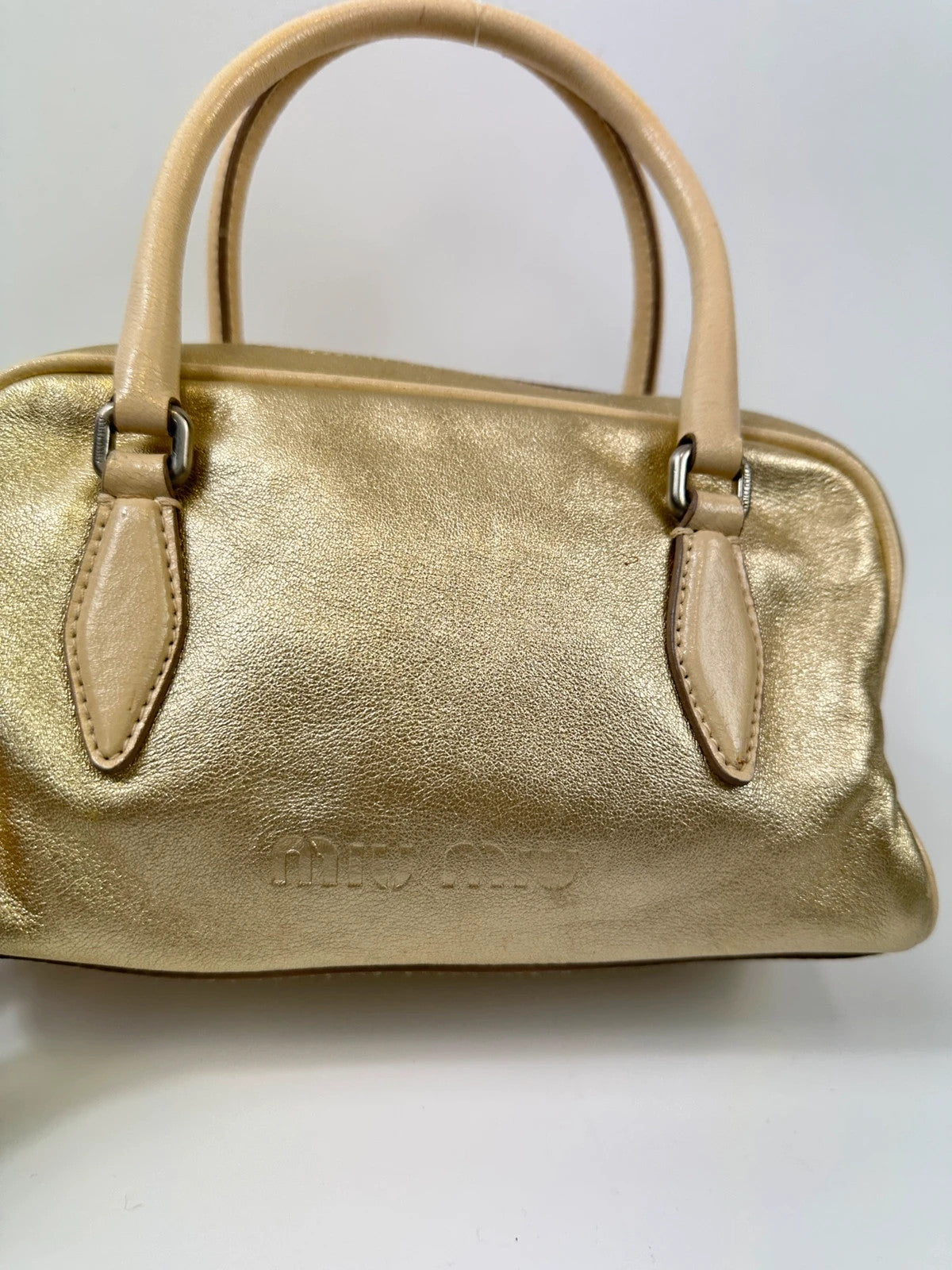 Miu Miu gold leather mini handbag with shiny glitter finish and logo detail.