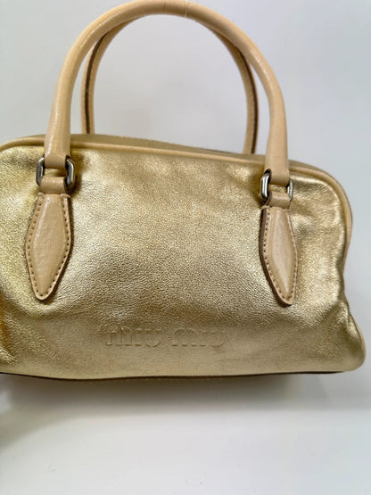 Miu Miu gold leather mini handbag with shiny glitter finish and logo detail.
