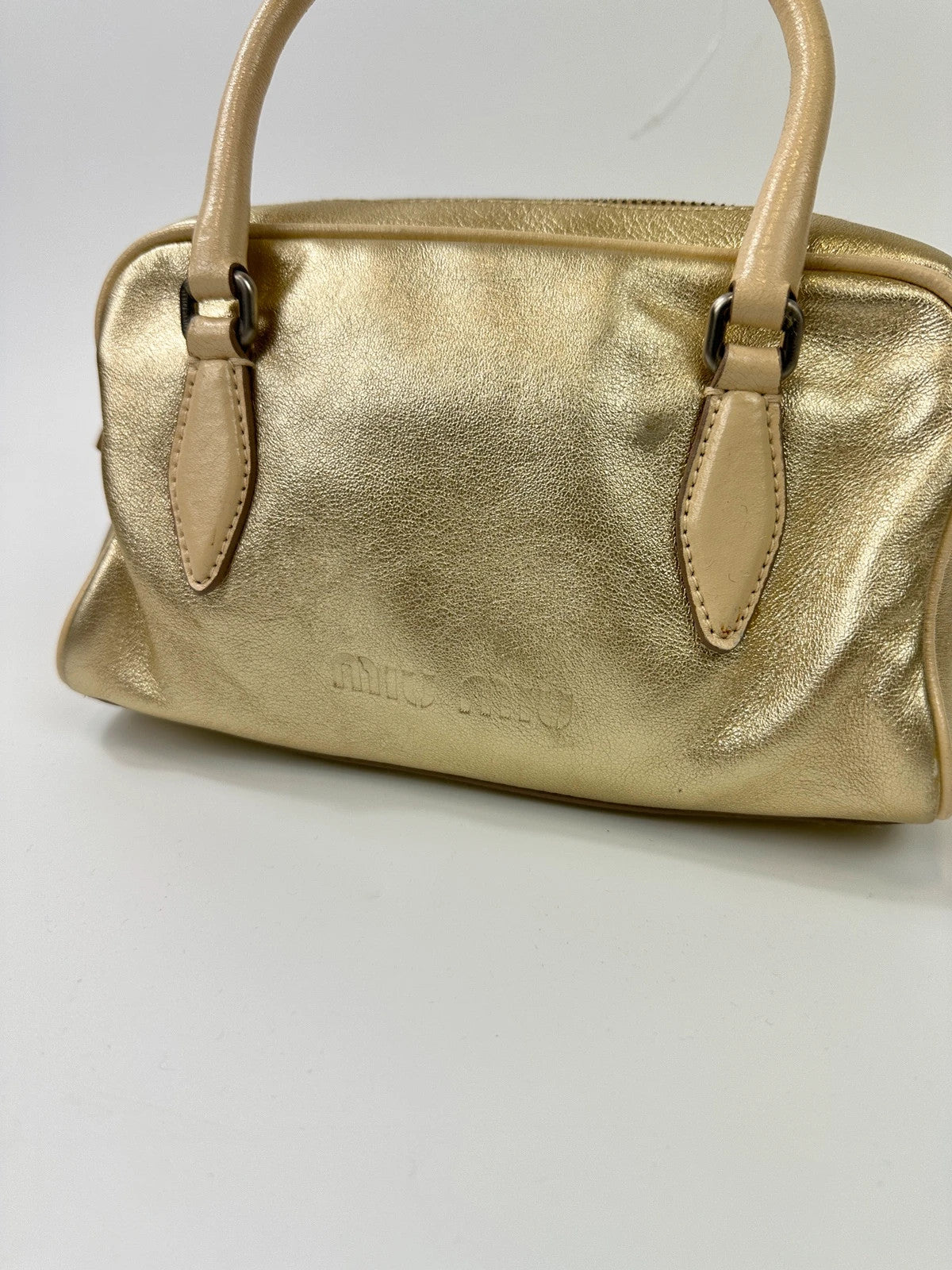 Miu Miu gold leather mini handbag with shiny glitter finish and logo detail.