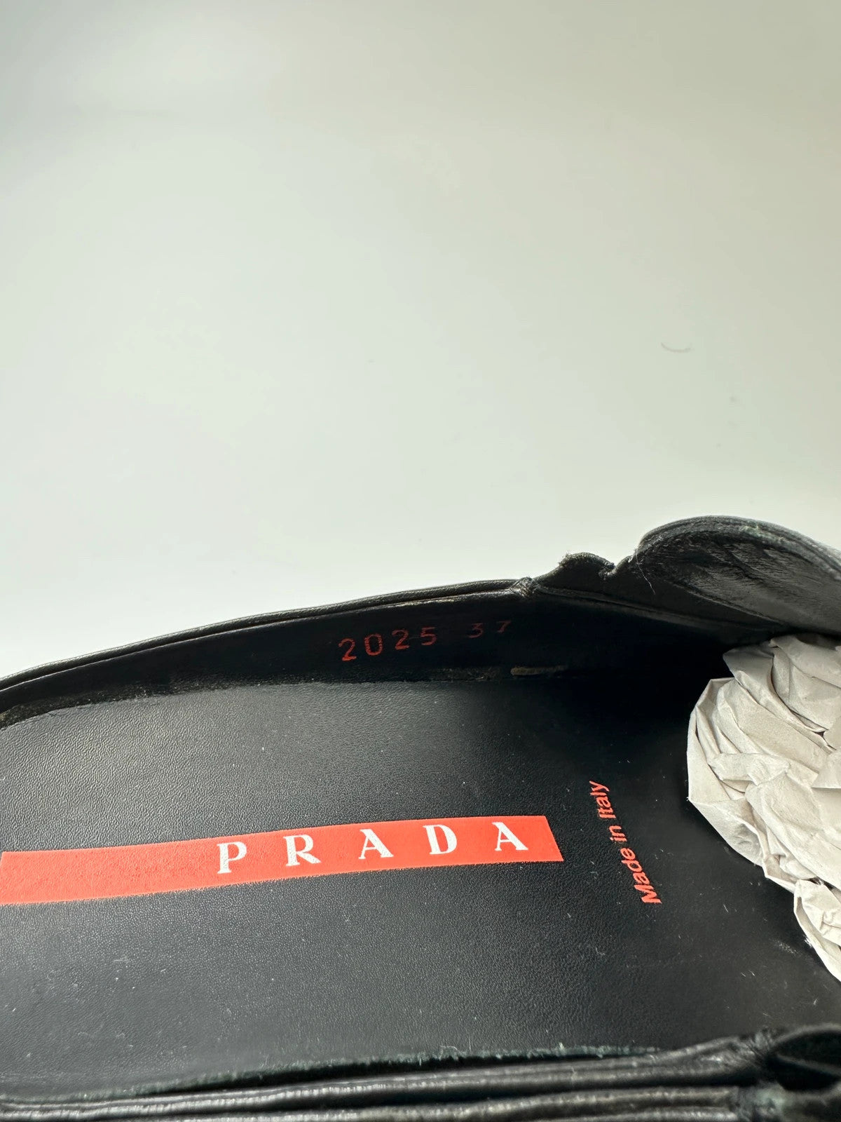 Prada black leather mules with ventilation, minimalist design from SS99 collection.