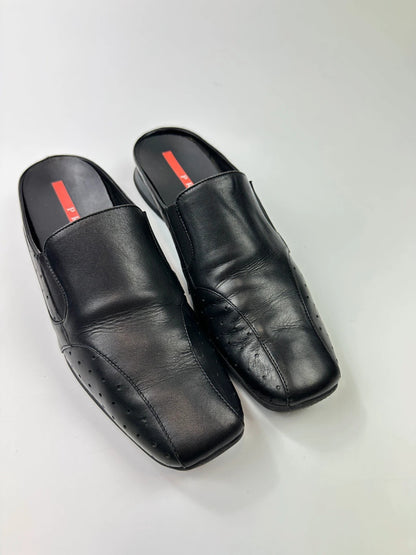 Prada black leather mules with ventilation, minimalist design from SS99 collection.
