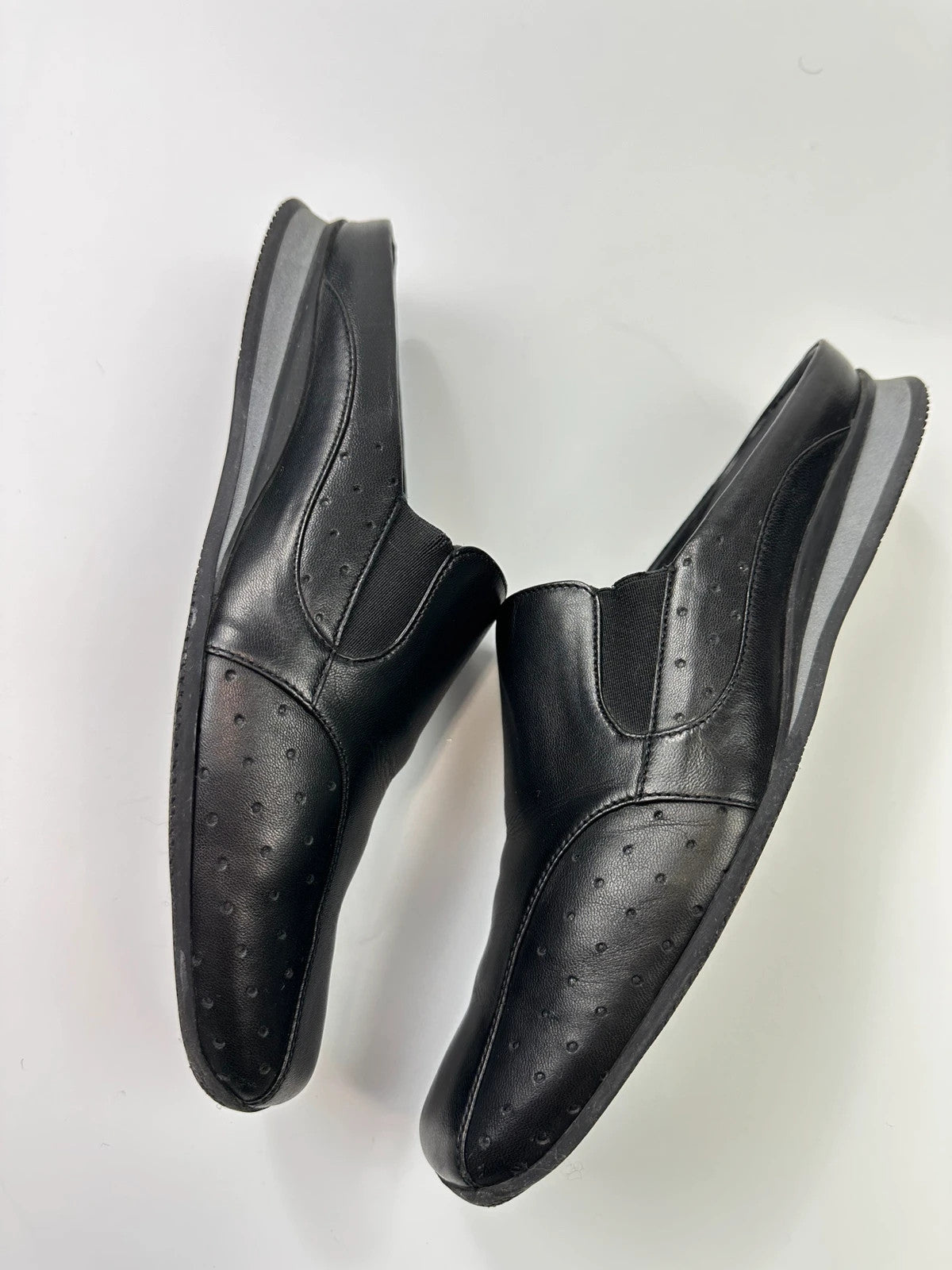 Prada black leather mules with ventilation, minimalist design from SS99 collection.