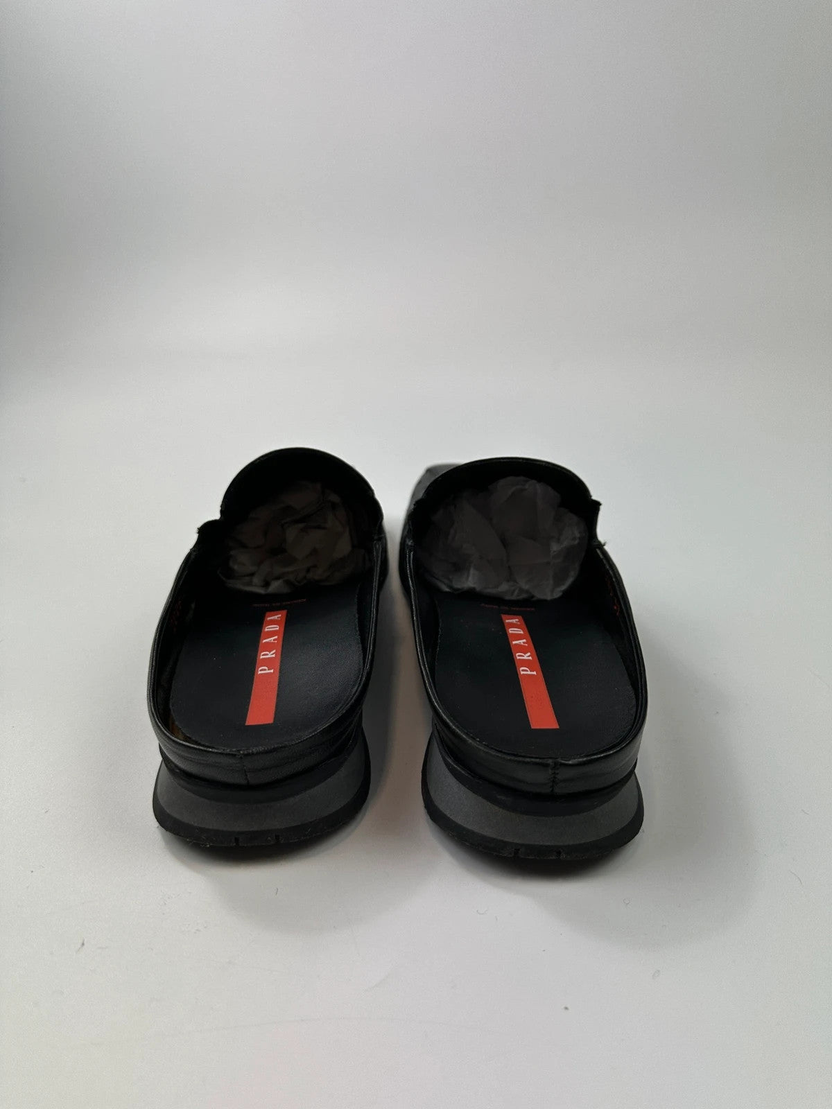 Prada black leather mules with ventilation, minimalist design from SS99 collection.