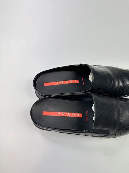 Prada black leather mules with ventilation, minimalist design from SS99 collection.