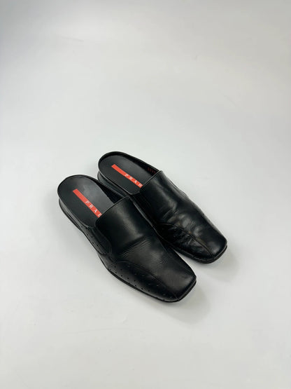 Prada black leather mules with ventilation, minimalist design from SS99 collection.