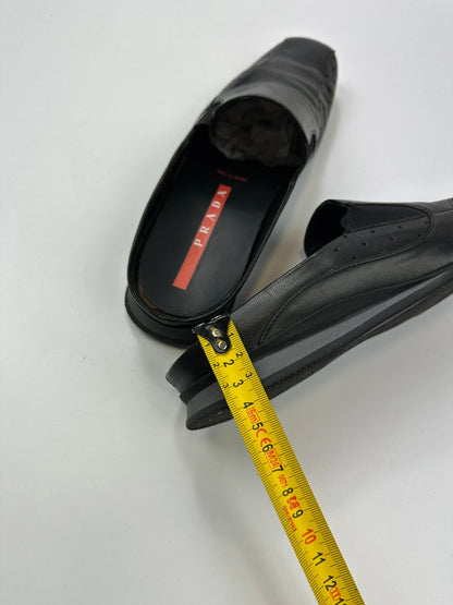 Prada black leather mules with ventilation, minimalist design from SS99 collection.