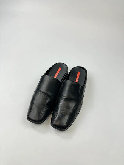 Prada black leather mules with ventilation, minimalist design from SS99 collection.