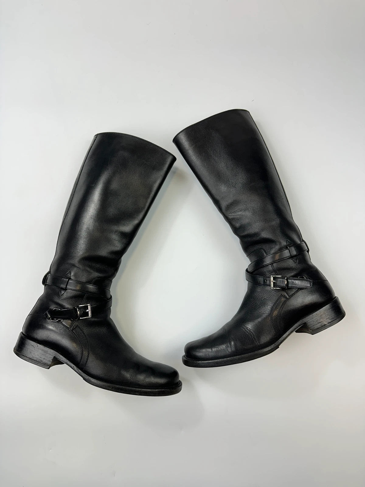 Prada black leather knee-high boots with high belt detail and minimalist design.