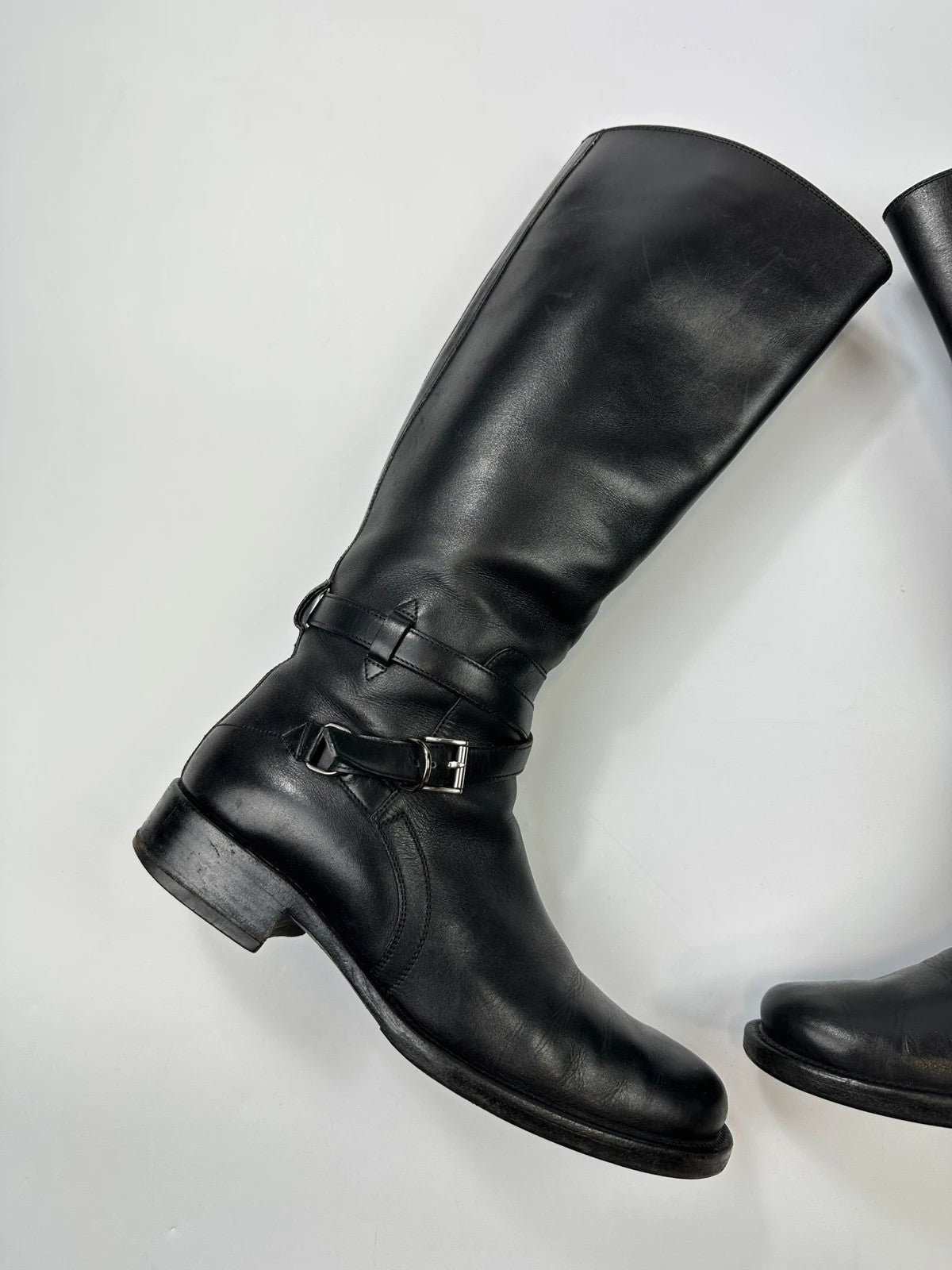 Prada black leather knee-high boots with high belt detail and minimalist design.