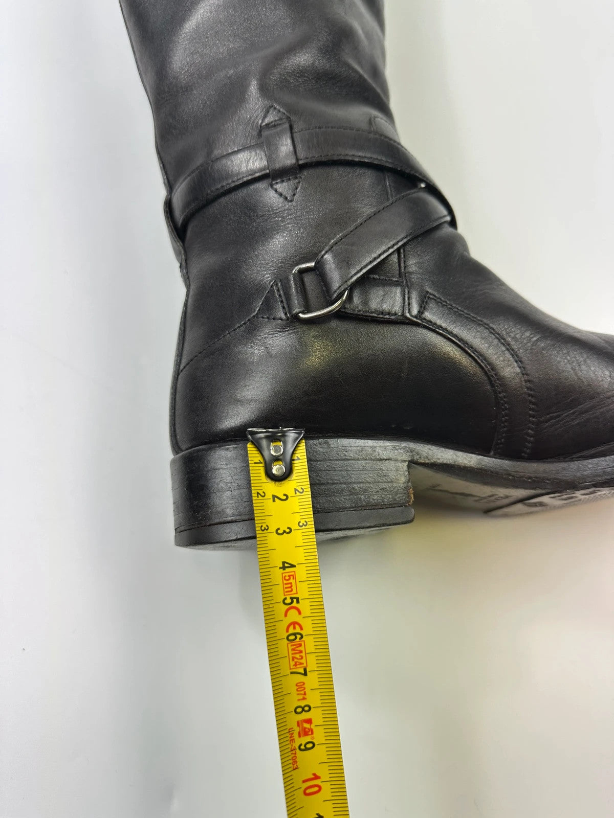 Prada black leather knee-high boots with high belt detail and minimalist design.