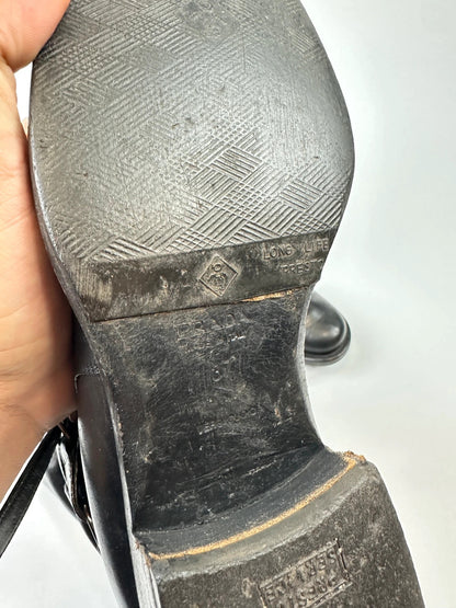 Prada black leather knee-high boots with high belt detail and minimalist design.