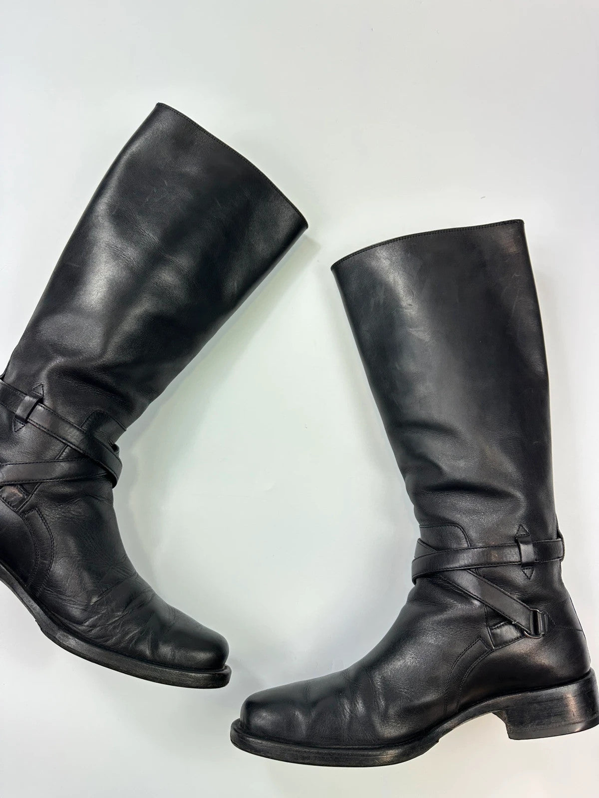 Prada black leather knee-high boots with high belt detail and minimalist design.