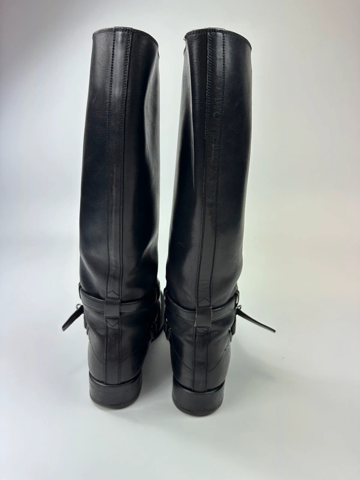 Prada black leather knee-high boots with high belt detail and minimalist design.