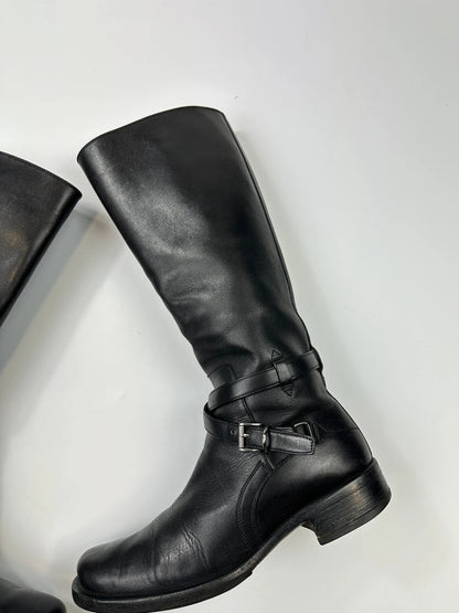 Prada black leather knee-high boots with high belt detail and minimalist design.